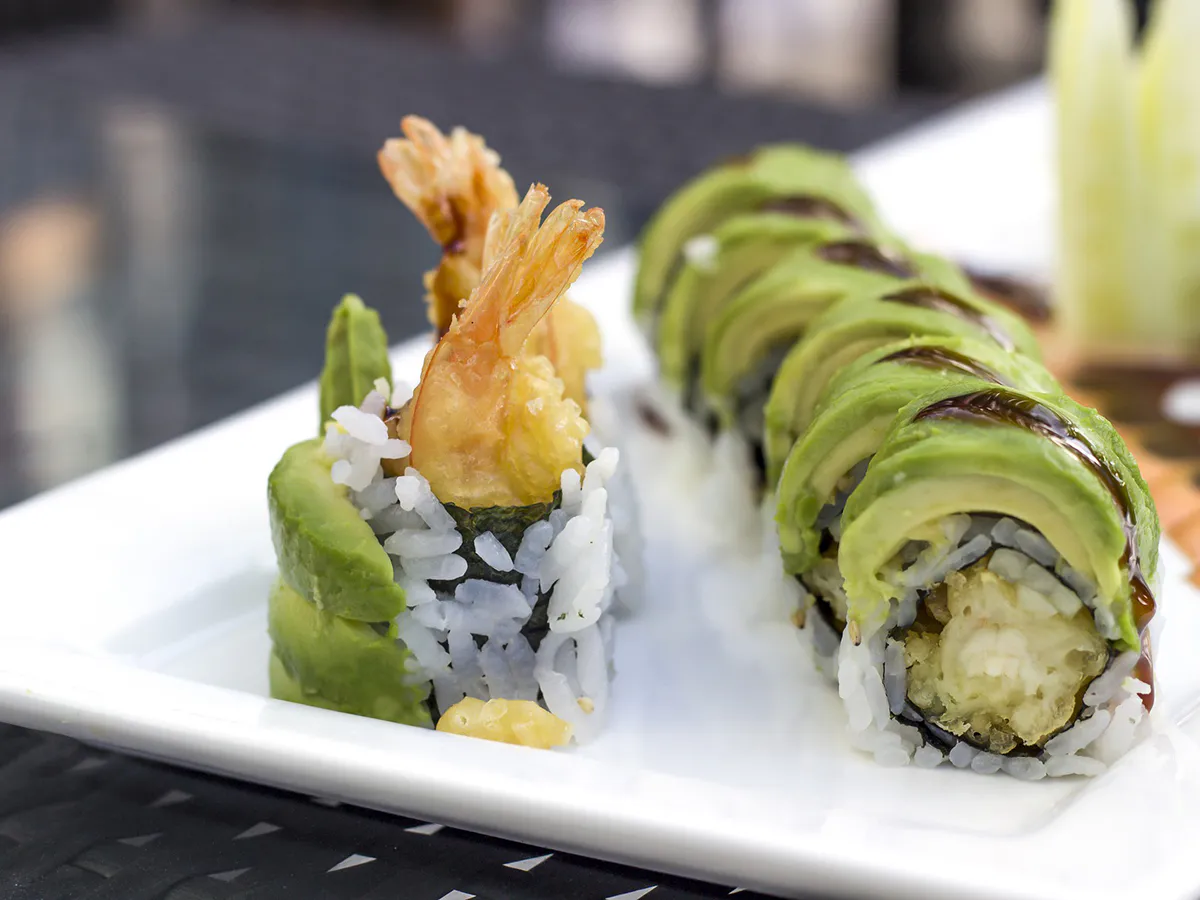 Tempura shrimp avocado sushi rolls on white plate